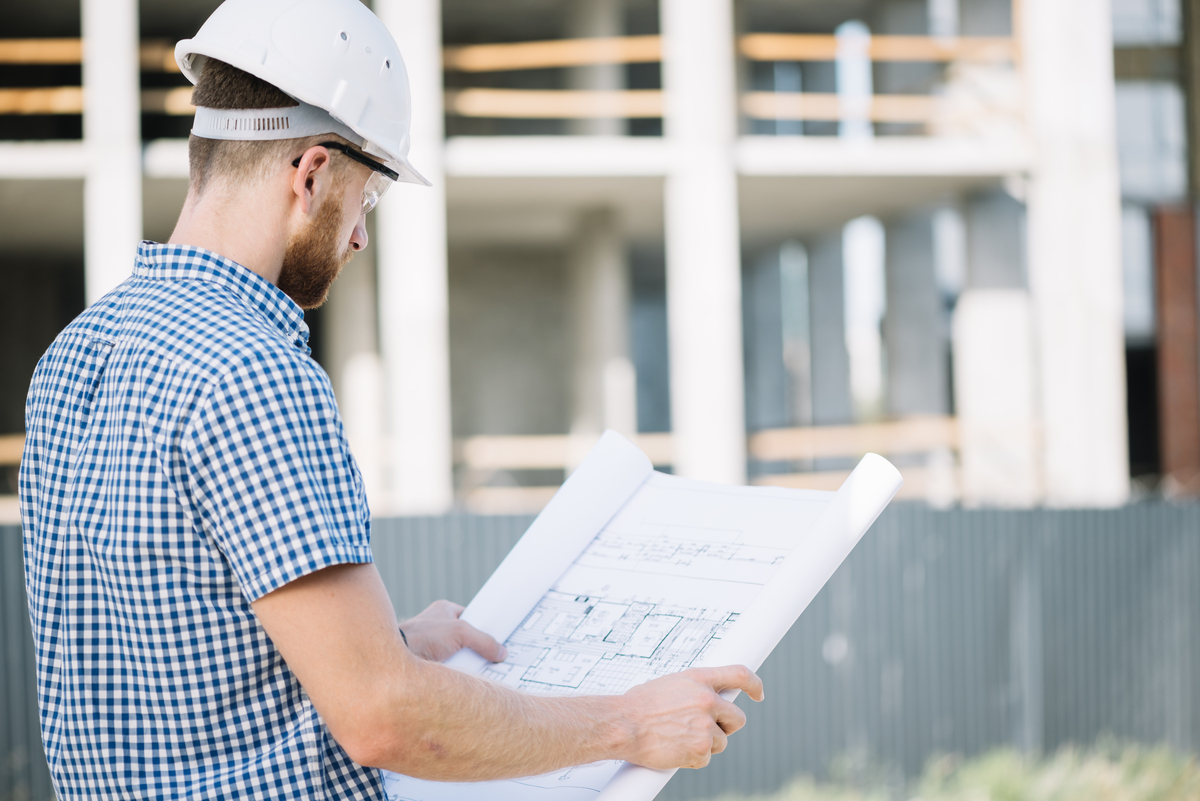 Side-View-Man-With-Blueprint-Estimator-in-Construction