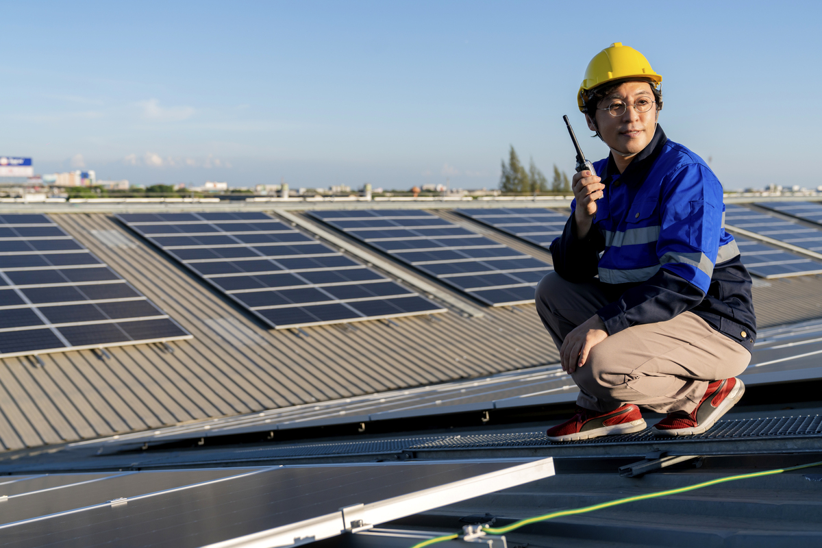 specialist-technician-professional-engineer-with-laptop-tablet-maintenance-checking-installing-solar-roof-panel-factory-rooftop-sunlight-engineers-holding-tablet-check-solar-roof-Solar-Panel-in-Building