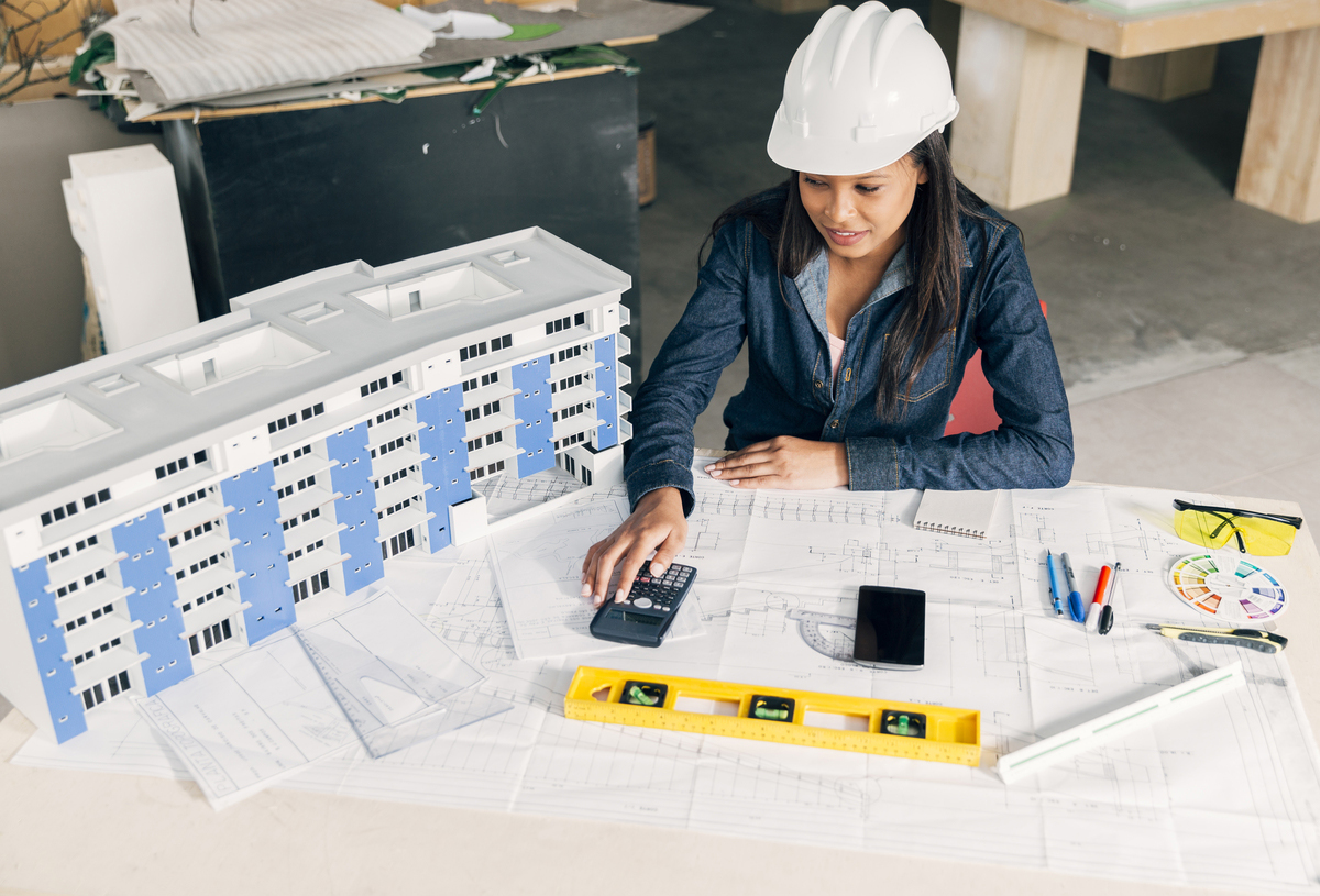 lady-safety-helmet-sitting-near-model-building-5D-BIM