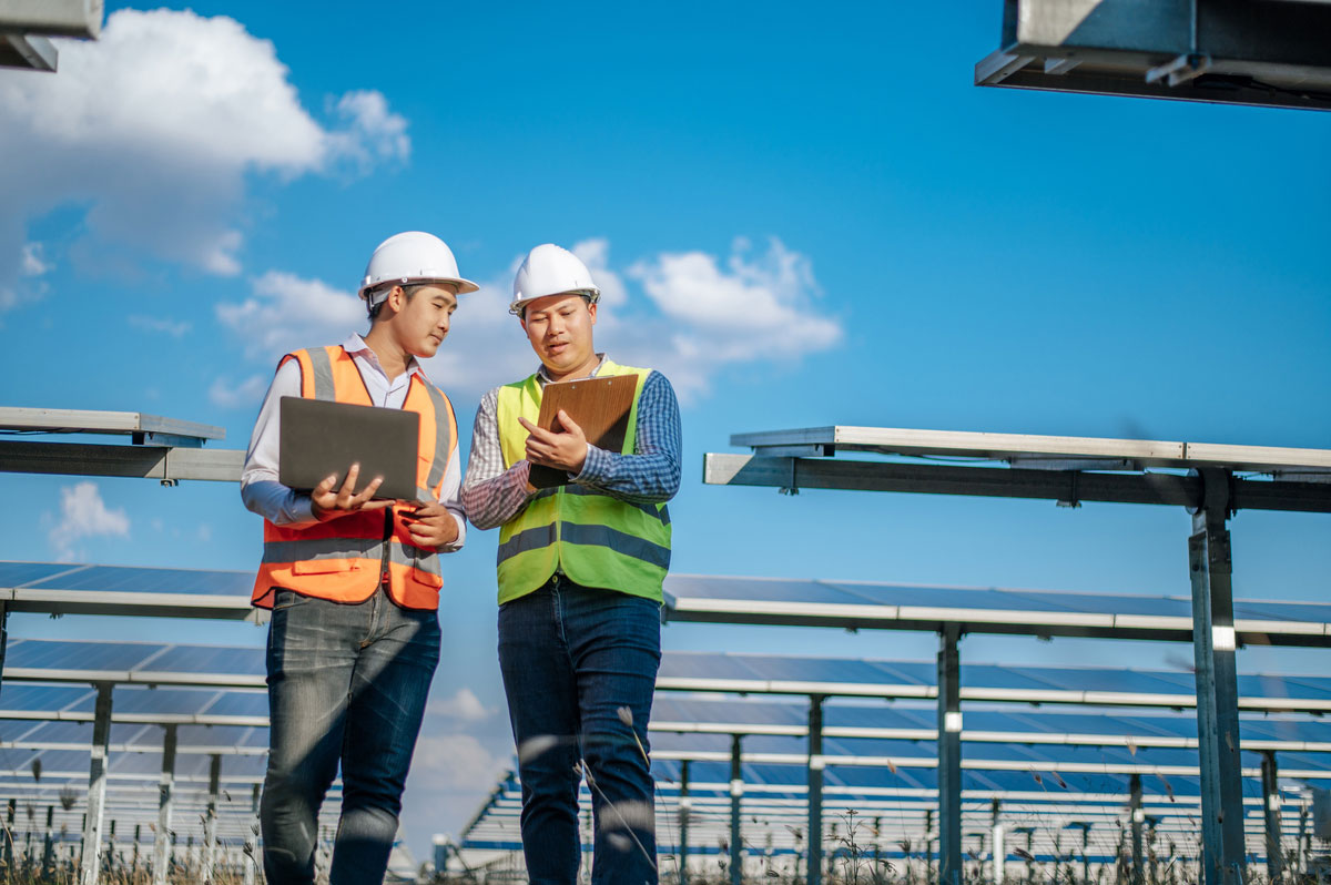 young-asian-technician-man-colleague-safety-uniform-checking-operation-sun-photovoltaic-solar-panel-use-with-his-digital-transformation-manager