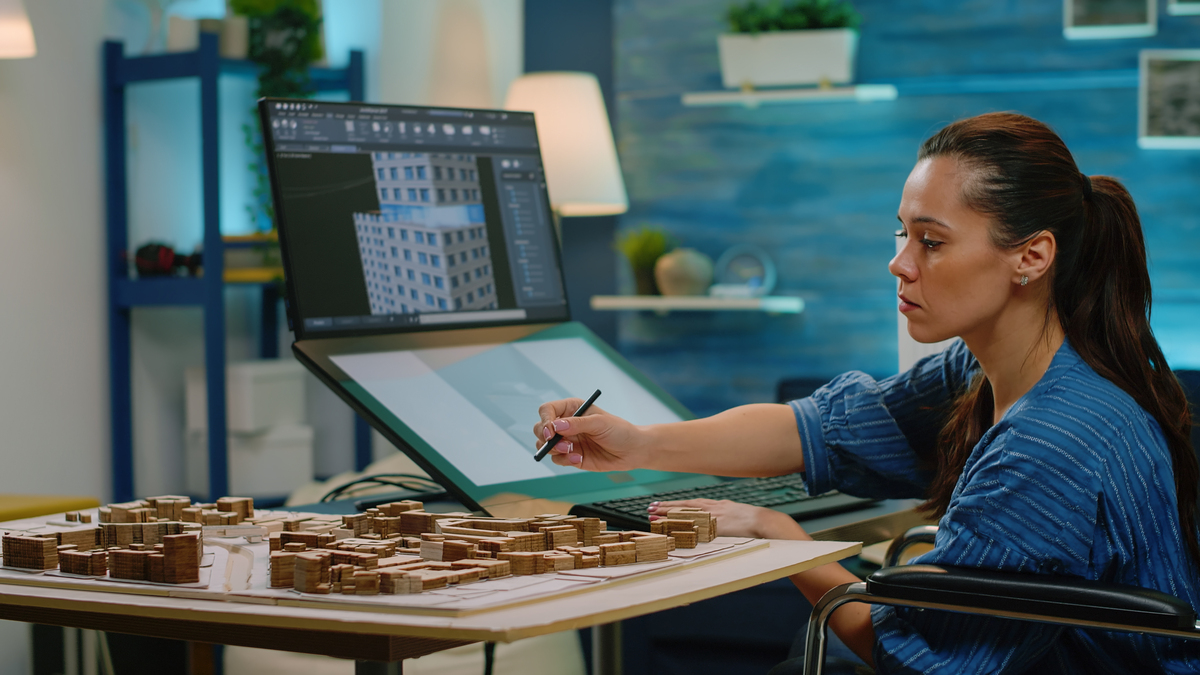 Woman-With-a-Disability-Using-the-Touch-Screen-for-Construction-Layout-at-the-Office-Architect-in-a-Wheelchair-Analyzing-The-Building-Construction-AI-Software