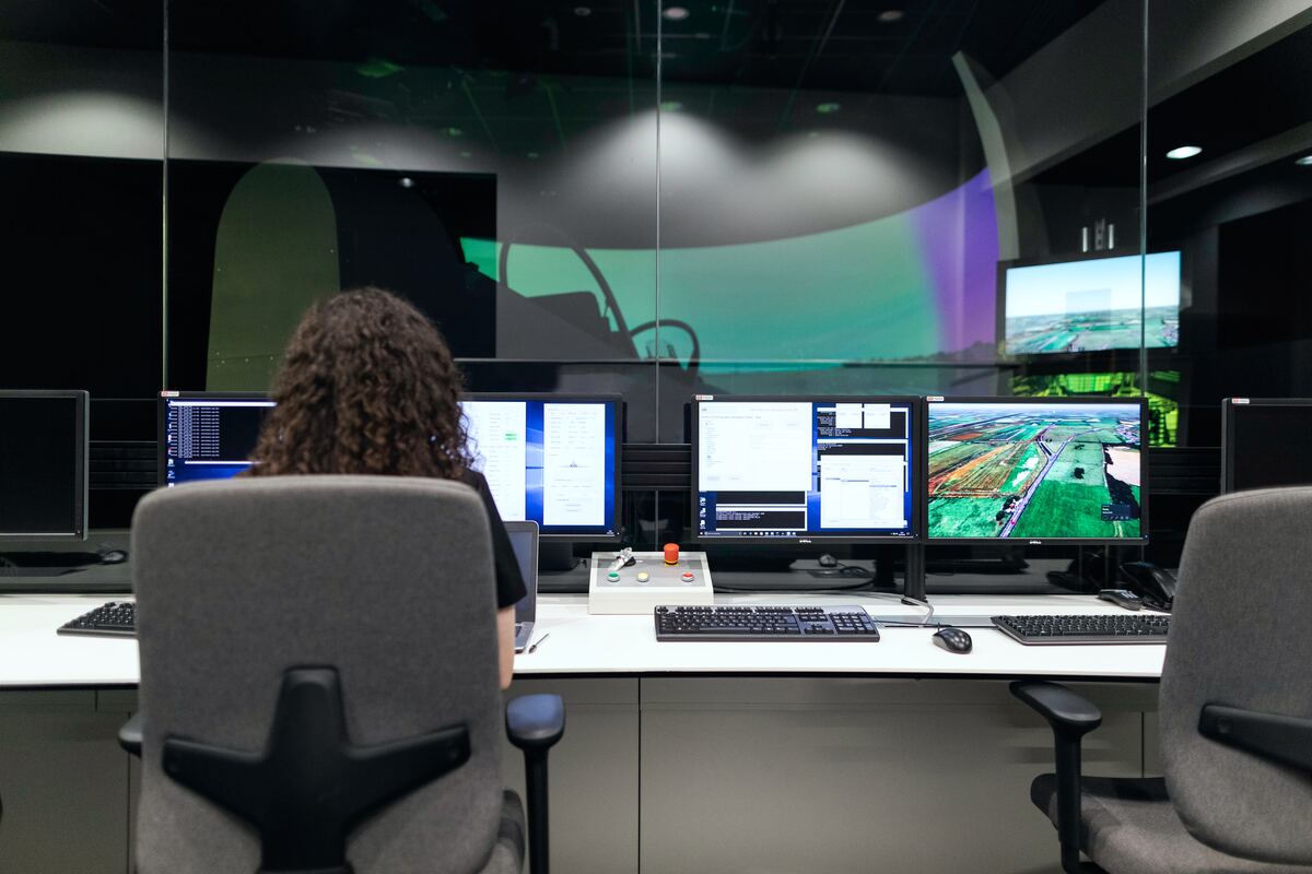 Woman-Sitting-on-Black-Office-Rolling-Chair-in-Front-of-Computer-Monitor-Construction-AI-Software