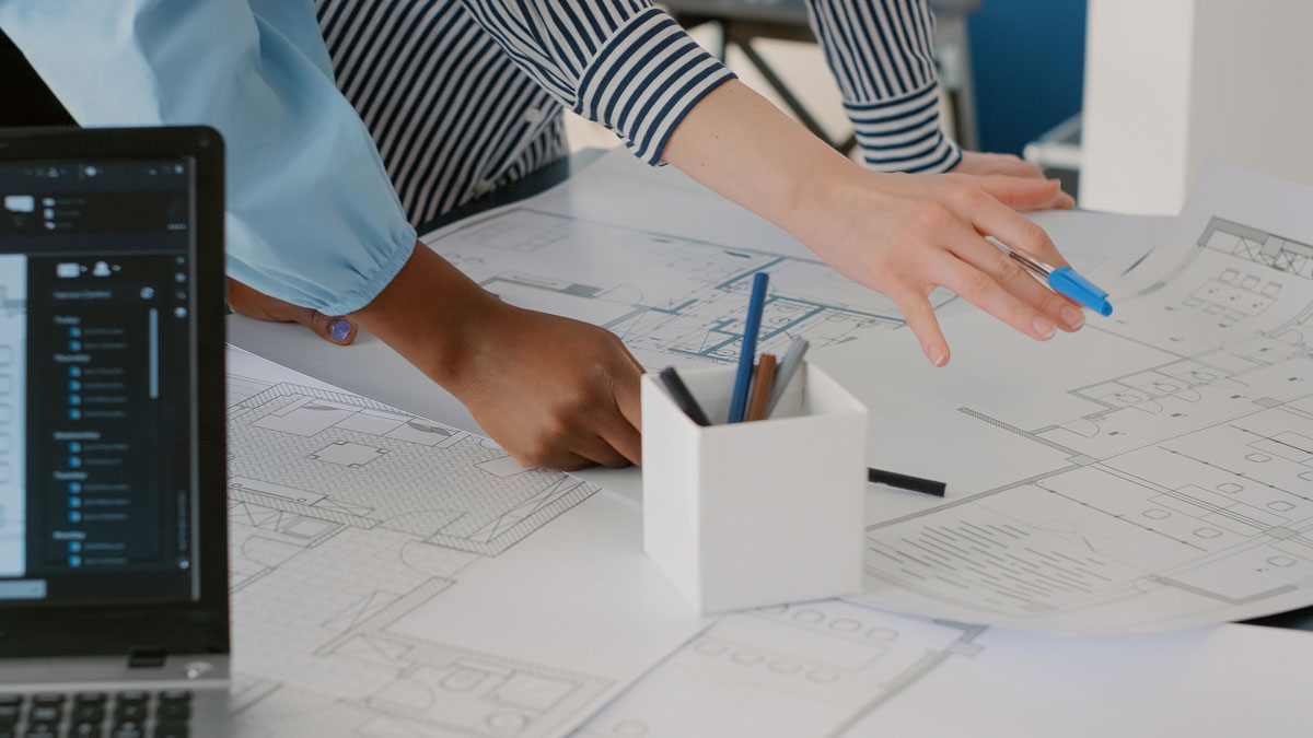 close-up-architects-doing-teamwork-design-blueprints-plans-building-model-table-team-women-working-with-industrial-sketch-layout-print-plan-architectural-project-construction-takeoff