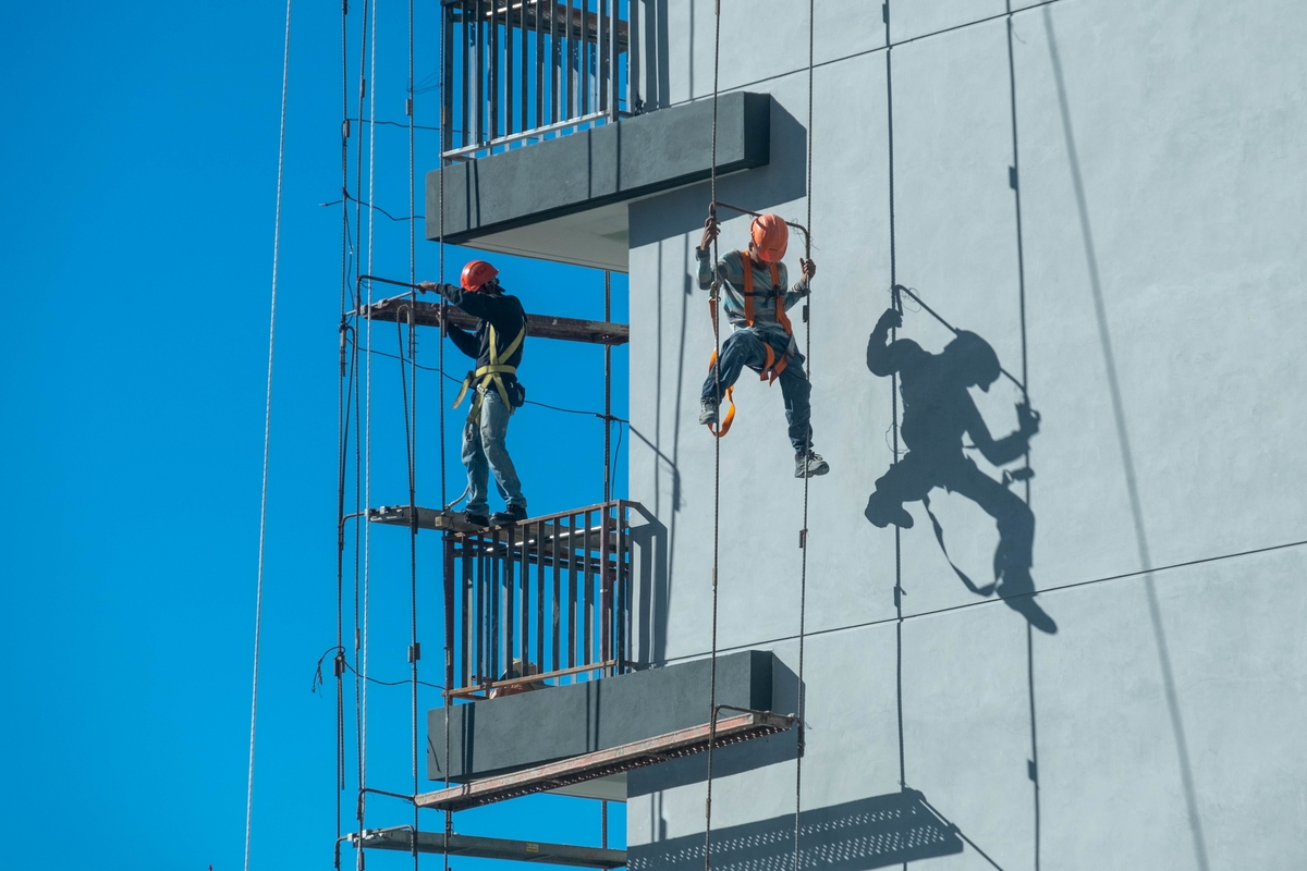 couple-workers-fixing-climbing-scaffolding-while-following-all-building-maintenance-safety