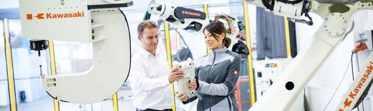 A-Man-and-A-Woman-Standing-in-front-of-A-Robot-Industrial-Internet-of-Things