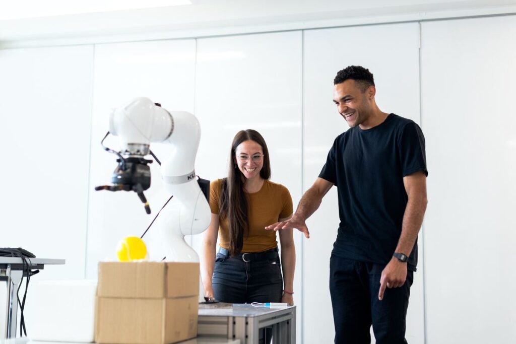 Man-in-Blue-Crew-Neck-T-shirt-Standing-Beside-Woman-in-Orange-Tank-Top-Industrial-Internet-of-Things