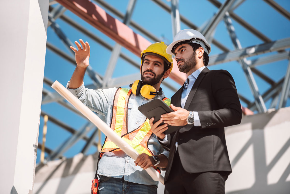 Civil-Engineer-Construction-Worker-Manager-Holding-Digital-Tablet-Blueprints-Talking-Planing-About-Construction-Site-Cooperation-Teamwork-Concept-Construction Process