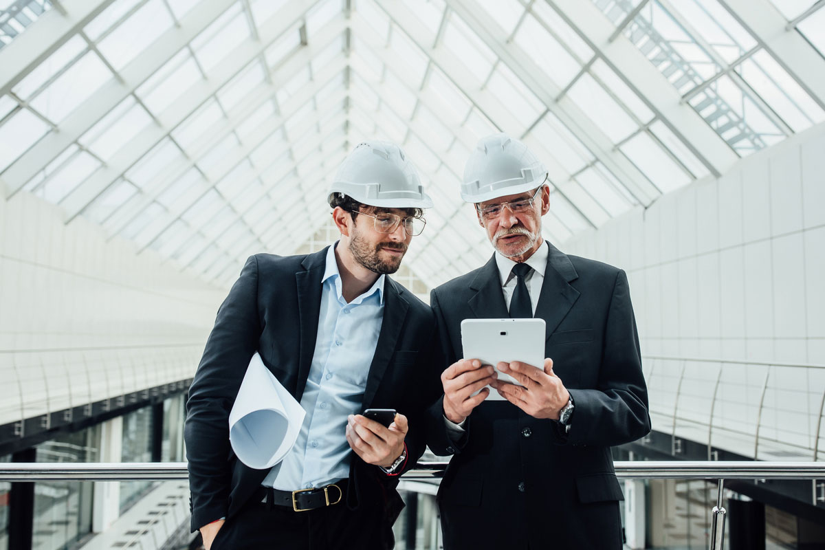 two-successful-entrepreneur-helmet-with-project-laptop-new-buildings-stay-near-glass-roof-discussing-Digital-Transformation-Consulting