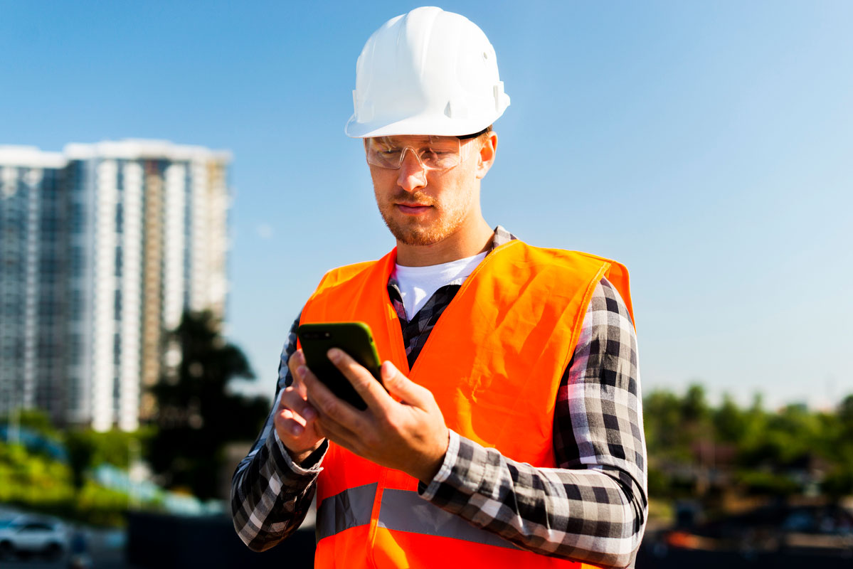 medium-shot-engineer-looking-phone-Mobile-Construction-Technology