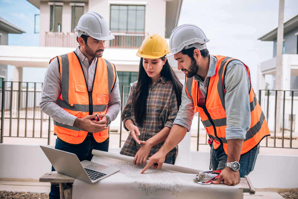 civil-engineer-construction-worker-architects-wearing-hardhats-safety-vests-are-working-together-construction-site-building-home-cooperation-teamwork-concept-Building-Management-System