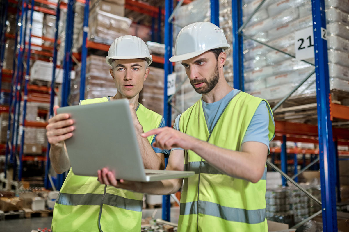 two-men-looking-laptop-deciding-work-question-warehouse-Site-Logistics-in-Construction