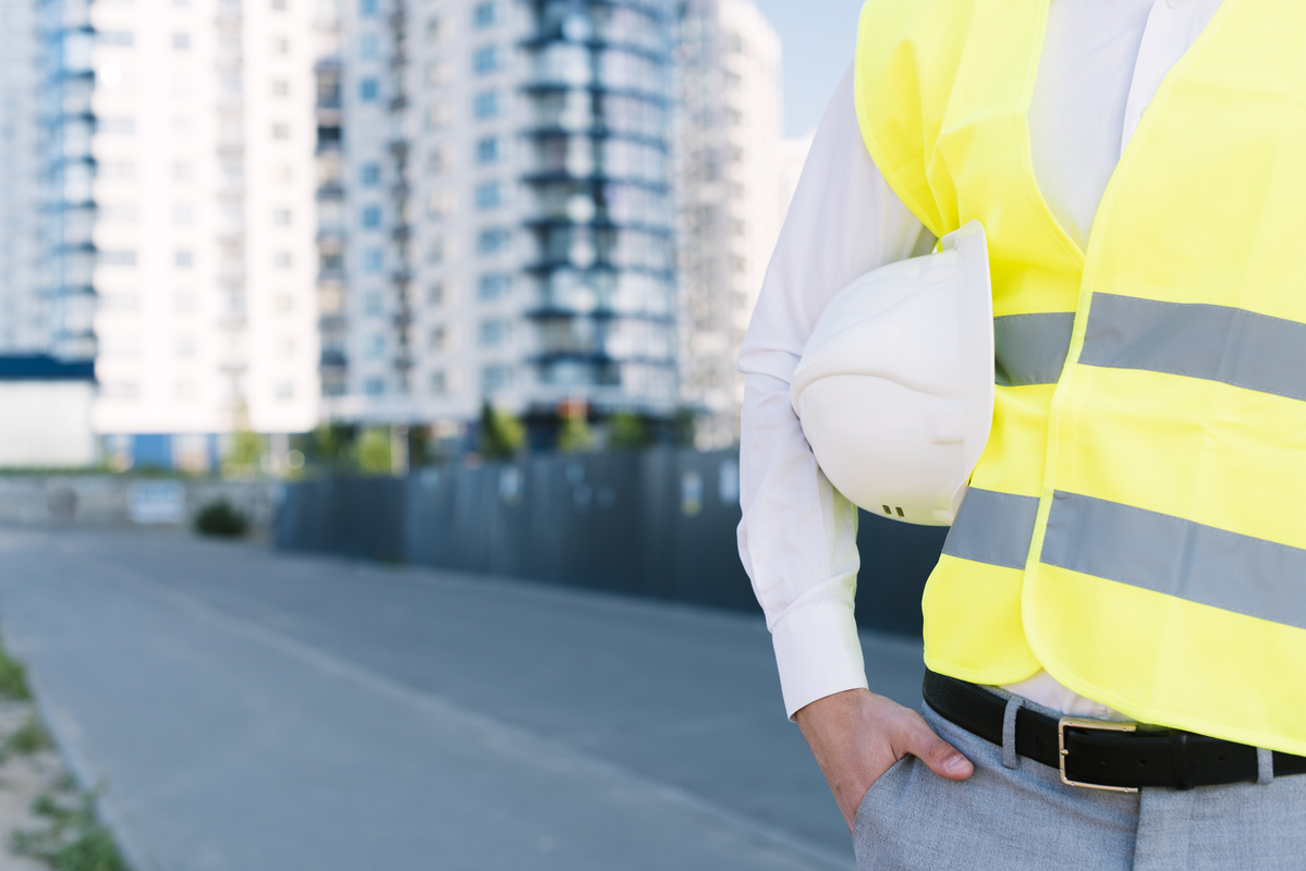 Close-Up-Man-With-Ssafety-Vest-Holding-Helmet