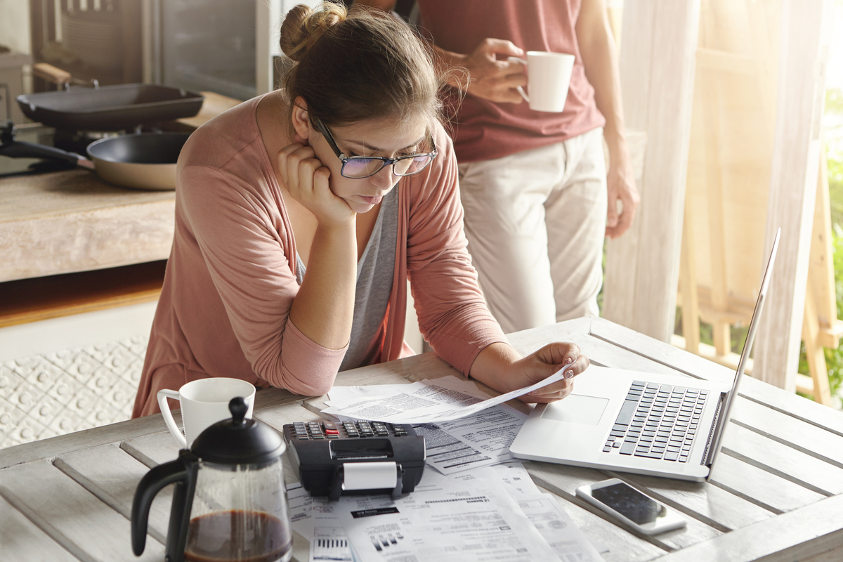 young-housewife-dressed-casually-focused-paperwork-Cost-Overruns-in-Construction