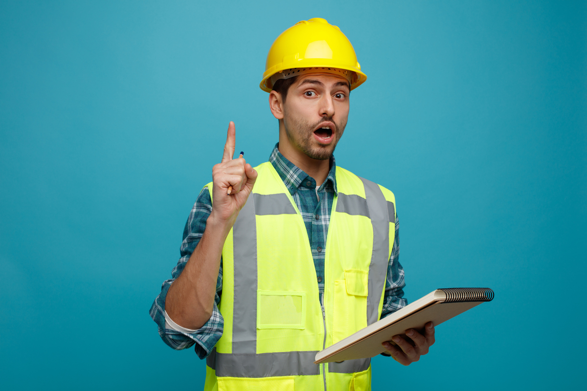 impressed-young-male-engineer-wearing-safety-helmet-uniform-with-construction-punch-list