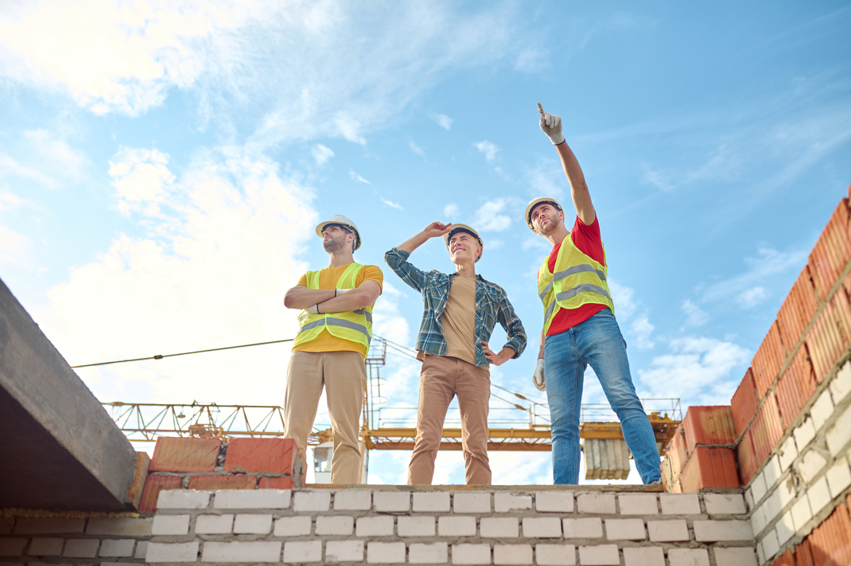 men-standing-brick-wall-building-Construction-Rework