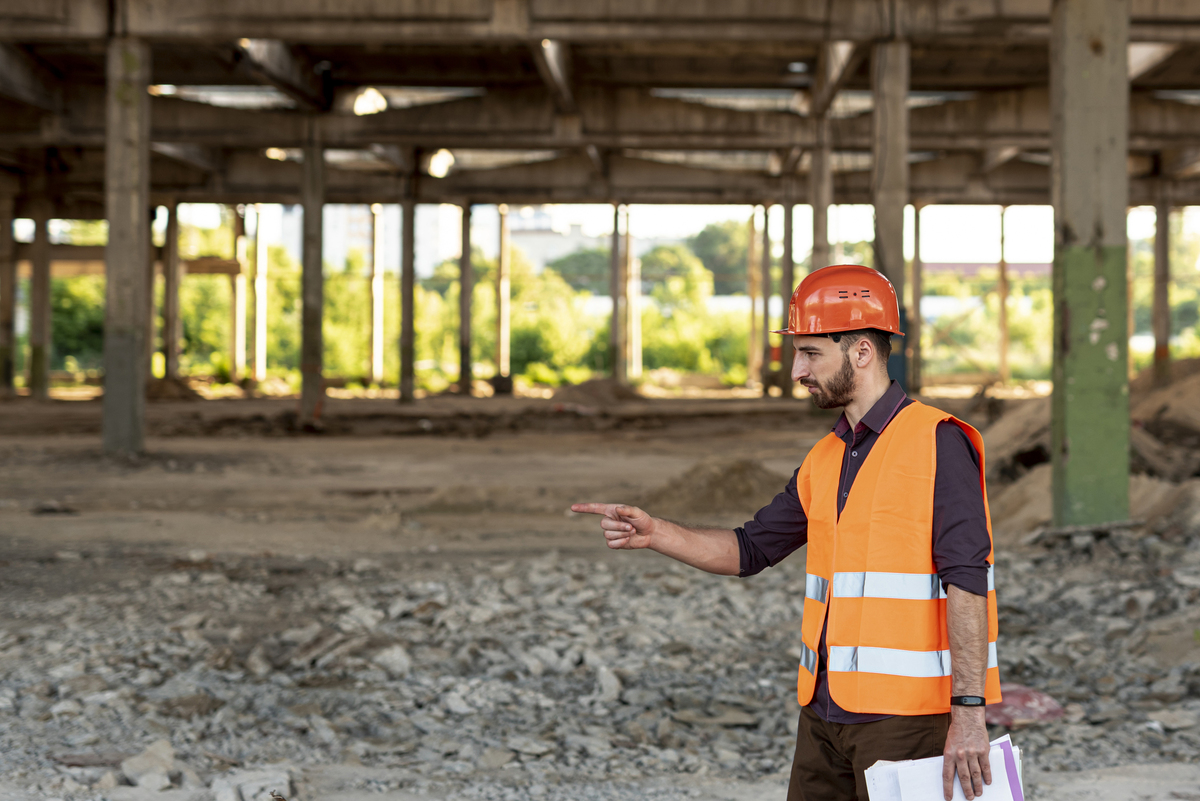 Construction-Company-in-India-side-view-man-with-orange-vest-pointing