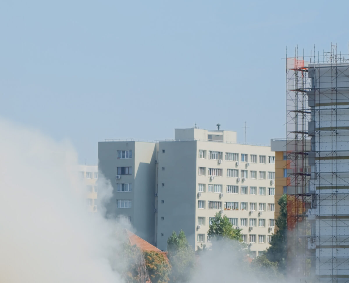 view-flames-getting-out-burning-house-city-landscape-fumes-smog-going-out-building-fire-while-firefighters-trying-extinguish-dangerous-smoke-with-water-Climate-Change-Impact-on-Buildings