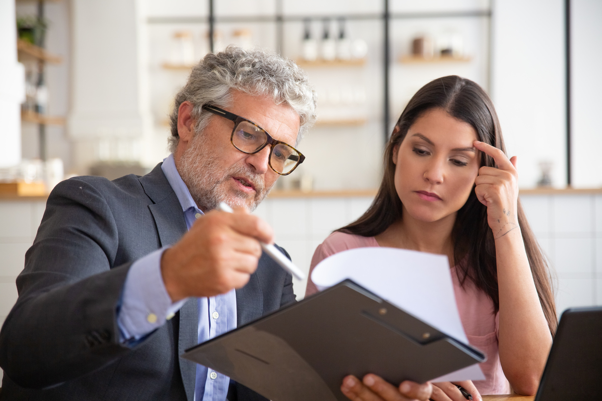 serious-mature-legal-advisor-reading-analyzing-explaining-document-female-customer-Construction-Disputes